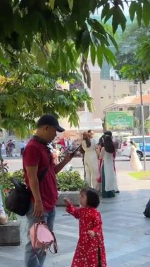 Tatilde giyinmiş insanlar geleneksel Vietnamlı giysiler küçük kız baba kızının cep telefonuyla oynadığını fark etmiyor çocuk Ho Chi Minh Şehri Vietnam 09.30.2024