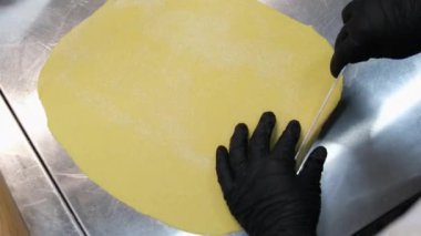 Şef spagettiyi dilimliyor. Makarna hamuruna yakın çekim. Erişte yapıyorum. hamuru kes erişteyi pişir