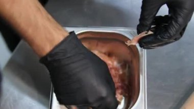 Siyah eldivenli, tanınmayan bir şef insanların elleri salata parçalarını küçük parçalara ayırır. Salata için prosciutto böl.