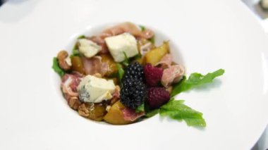 Prosciutto ile salata porsiyonlu jambon aperatifi portakal ve nar karışımında servis edilir. Ahşap arka planda taze sebzeli lezzetli salata. . 
