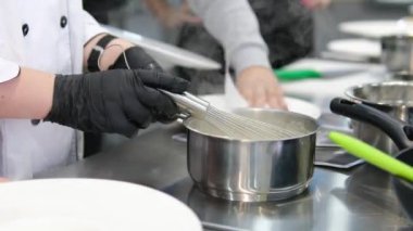 Aşçı, Püre 'yi Kazandan Ladle' la İki Tabağa Döker. Krema çorbasını bir tabağa dök.