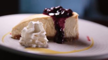 New York peynirli keki, yaban mersini kremalı ve buruşuk çatallı. Beyaz bir tabakta lezzetli bir tatlı kes. Reçelli ve kremalı cheesecake