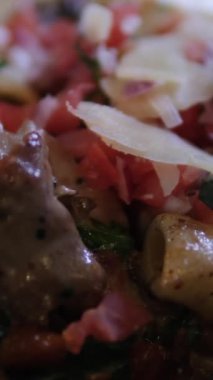 Parmesan mantarlı ve siyah tabakta sebzeli mum ışığında akşam yemeği makarnası. Pahalı bir restoranın karanlık arka planında. Yüksek kalite 4k görüntü