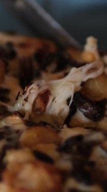 Karanlık bir restoranda çatal ve bıçakla yemek yerken tabaktaki dilimlenmiş pizza dilimlenmiş bilinmeyen bir kadının ellerini kapatın. Karanlıkta bir dilim pizza kes.