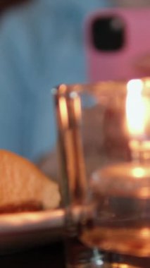 Reçelli peynirli kek ve reçelli genç kız mum ışığında genç blogcuların restoranında akşam yemeği filme alıyor. Yüksek kalite 4k görüntü