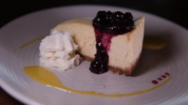 Yabanmersini soslu cheesecake. Lezzetli New York peynirli kekinden çatalla ısırmak. Cheesecake yiyorum. Frenk üzümlü peynirli kek.