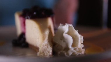 Yabanmersini soslu cheesecake. Lezzetli New York peynirli kekinden çatalla ısırmak. Cheesecake yiyorum. Frenk üzümlü peynirli kek.
