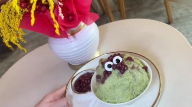 Masada gözleri olan yeşil bir kasede çirkin bir dondurma. Yüksek kalite 4k görüntü