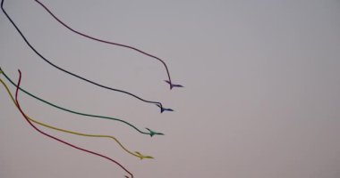 Mavi gökyüzünde renkli bir uçurtma. Mavi gökyüzüne ve beyaz bulutlara karşı gelişen bir uçurtmanın yavaşlatılmış çekimi. Uçurtma gösterisi Renkli uçurtmalar Akşam gökyüzünde uçar