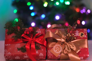 Parlayan parti ışıkları hediye kutuları arka plan bokeh karşı büyük bir kırmızı yay ile. Lüks yeni yıl hediyesi. Noel hediyesi. Noel hediye kutusu ile arka plan. Noel Kutlamaları.