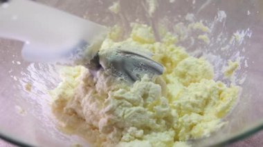 Aşçı ev yapımı süzme peynir, tavuk yumurtası, şeker ve un karıştırıcı ile ayini böler. Kaymaklı krep yapma süreci. Ağır çekim. Yüksek kalite 