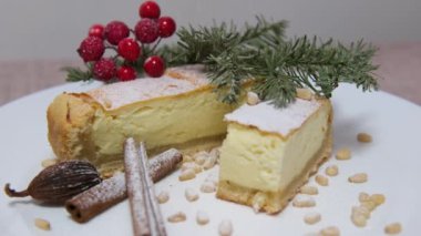 Peynirli krep, pudra şekeri, reçel ve kahverengi tabakta naneli peynirli kek. Noel ağacının arka planında yeni yıl pastası