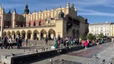 Çocuklar okul gezisinde Krakow tarihi pazar meydanı, Krakow, Polonya 11.06.2024 ile dışarıda bir konferans dinliyorlar.