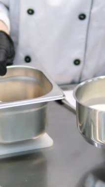 Ev Mutfağı 'nda ocağın üzerine süt dökülüyor. Genç kadın yulaf ezmesi pişirmek için bir tavaya süt döküyor. Sağlıklı yiyecekler, yemek, diyet konsepti. Tencerede sıcak süt