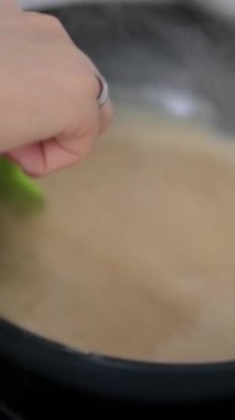 Şekerleme makinesi karamel hazırlamak için tavada şeker eritiyor. Evde karamel yapıyorum. Şekerleme ve kek kavramı. yemek karamelli süt ekle