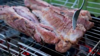 Şef restoranda ızgara biftek çeviriyor. Izgarada et pişirmek için maşa kullanmak. Profesyonel bbq yemekleri nefis. Izgara et.