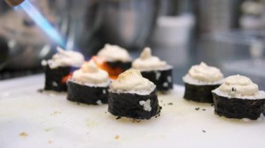 Tüm pişirme işlemleri adım adım. Asya mutfağında sushi pişirirken peynir kapaklı bir aşçılık sınıfında meşale suşi tempolu hamur işi ve avokado ile ekmek kırıntıları kullanın..
