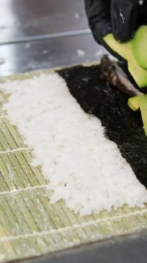 Tüm pişirme işlemleri adım adım. Asya mutfağında sushi pişirirken peynir kapaklı bir aşçılık sınıfında meşale suşi tempolu hamur işi ve avokado ile ekmek kırıntıları kullanın..