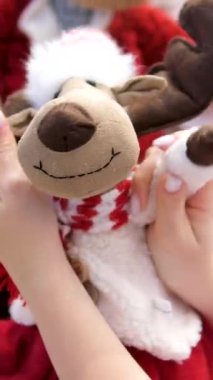 Profesyonel alışverişçinin elinde çam ağaçlı beyaz ve mor renkli komik geyik oyuncakları var. Kış indirimleri hariç. yumuşak oyuncak geyik