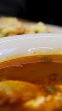 Kafedeki masada çorba solyanka var. Sebze ve et ahşap bir masada. Dikey videolar