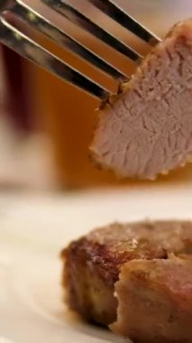 Bir tabak dikey videoda kızarmış et. Şaşlık 'ı çatal ve bıçakla kes, dikey videolar.