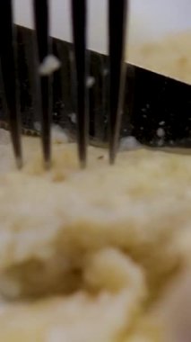 Kırmızı balıklı çatal ve bıçaklı krep, yakın plan, dikey videolar. Balık köftelerini çatal ve bıçakla kes.