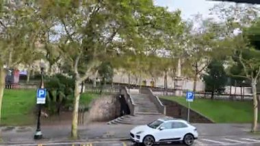Kırmızı hat gezileri Placa De Ispania, Ulusal Müze yağmurlu hava bulutlu Barcelona İspanya 11.03.2024 numaralı hareket halindeki turist otobüsünden cadde manzaralı.