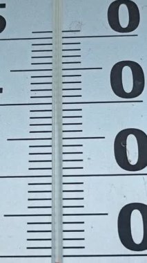 Evin duvarında büyük bir açık hava termometresi var. Yakın çekim, dikey video. Yüksek kalite 4k görüntü