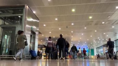 Kadın ve erkeklerin hareket halindeki halkları, çantalı sırt çantalarıyla ve şehir sakinleri Rodalies de Catalunya tren istasyonu Barcelona İspanya 11.03.2024 'te çıkmak veya girmek için acele ederken kameranın önünden geçiyor.