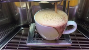 Kahve makinesinin fincanından kahve dökülüyor. Bardak rahatsız edici. Kakao tasarlanmamış. Yüksek kalite 4k görüntü