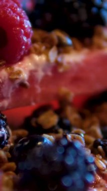 Karpuz, susam kreması, ev yapımı granola, donmuş böğürtlen, tofu kreması sağlıklı kahvaltılık ahududu ve karpuz yenilebilir çiçek restoranında böğürtlen. kırmızı tabakta servis ediliyor.