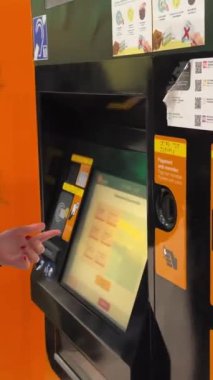 Kadın turistler Renfe Machine 'den bilet alıyorlar. Dillerini anlamıyorlar. Rodalies de Catalunya tren istasyonu Barcelona İspanya 11.03.2024' e bilet almak için fırsat kolluyorlar.