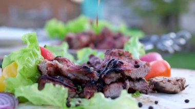 Bifteğin üstüne teriyaki sosu domatesli domuz eti ve karabiberli marul koy. Yüksek kalite 4k görüntü