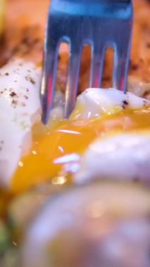 Haşlanmış yumurta ikiye bölünmüş ve yumurta sarısı sandviç ve tabakta akıyor. Lezzetli bir kahvaltı menüsünü yakından çek. Brunch zamanı Bali Kafe 'de ya da restoranda lezzetli yemekler servis edilir. Yüksek kalite
