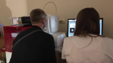 Modern klinikte özel optik cihazlarla gözleri test eden bir doktor. Oftalmolog Ukrayna 'nın 11.26.2024 sayılı muayenesi sırasında dijital mikroskop kullanan bir hastanın gözlerini inceliyor.