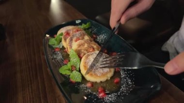 süzme peynirli pankek, manikürlü kadın eli, kızartılmış lor peynirini altın hamurla çevirmek için bir spatula kullanır. Genç bir kadın süzme peynirli krep hazırlıyor. Besleyici bir kahvaltı.