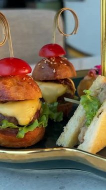 En azından yeşil tepside hamburgerli sandviçler ve tatlı kız parşömen tabağında yemek seçiyor. Yüksek kalite 4k görüntü