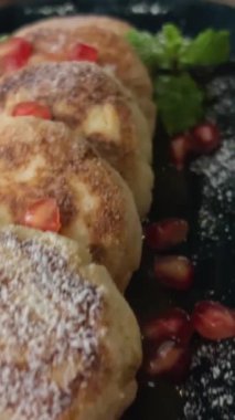 Eller tabağı glütensiz peynirli krep ile çevirir parlak mor dut reçeli ve yaban mersinleri aşırı yakın çekim yavaş çekim. Nane tohumları.