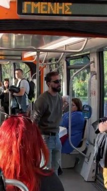 Şehirdeki tramvay trafiğindeki insanlar. Yunanistan Atina 11.16.2024