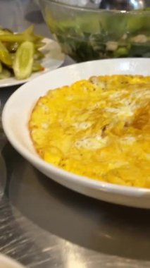Lezzetli, sağlıklı bir tostun yanında çırpılmış yumurta, doğu kahvaltısı yumurtaları turşulu, peynirli kremalı omlet, beyaz tabak, ekmek ve armut. Yatay çekim.