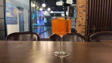 Boş bir restoranda, pipetli bir bardak portakal alkolü. Yüksek kalite 4k görüntü