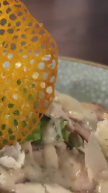 Koyu bir restoranda Sezar salatası. Mavi tabakta. Büyük kızarmış bıldırcın yumurtaları. Yüksek kalite 4k görüntü