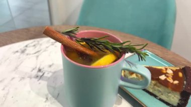 Karamelli ve fıstıklı escake. Turkuaz bardakla tabak kış çayı. Tarçınlı, limonlu ve biberiyeli. Yüksek kalite 4k görüntü