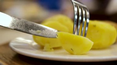 Zeplinler bir restoranda ekşi kremayla servis edilir. Yakın plan. Haşlanmış patates çatalı.