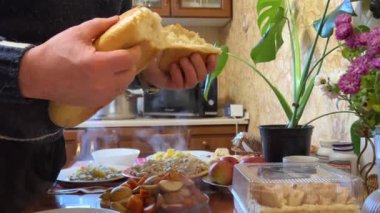 Ukrayna yemeği, haşlanmış patates, fırınlanmış elma kabağı ve Napolyon keki olan bir masanın arka planına ekmek kırmak köyün basit bir ailesidir. Yüksek kalite 4k görüntü