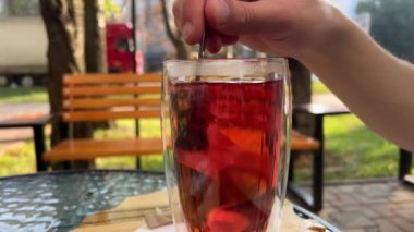 Çay içip şekerle karıştırmak. Bir bardak Türk çayı. Şekeri bardakta karıştır
