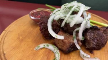 Tahta bir tahtanın üzerinde soğan turşusu ve dereotlu shashlik. Şiş kebap.