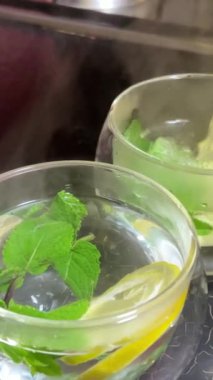 Limonlu cam bardaklara kaynamış su dök. Sıcak içecek. Yüksek kalite 4k görüntü