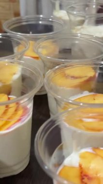 Ev yapımı jöle yapma işlemi. Plastik bardaklarda porsiyonlar halinde. Meyveli farklı katmanlar halinde jelatin dökülüyor. Yüksek kalite 4k görüntü