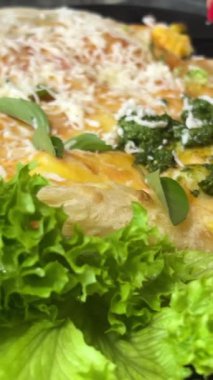 Lezzetli öğle yemeği lavaşıyla yumurta rendelenmiş peynir marul yaprakları bir parça lezzetli yemeği çatal ve bıçakla keser. Yüksek kalite 4k görüntü